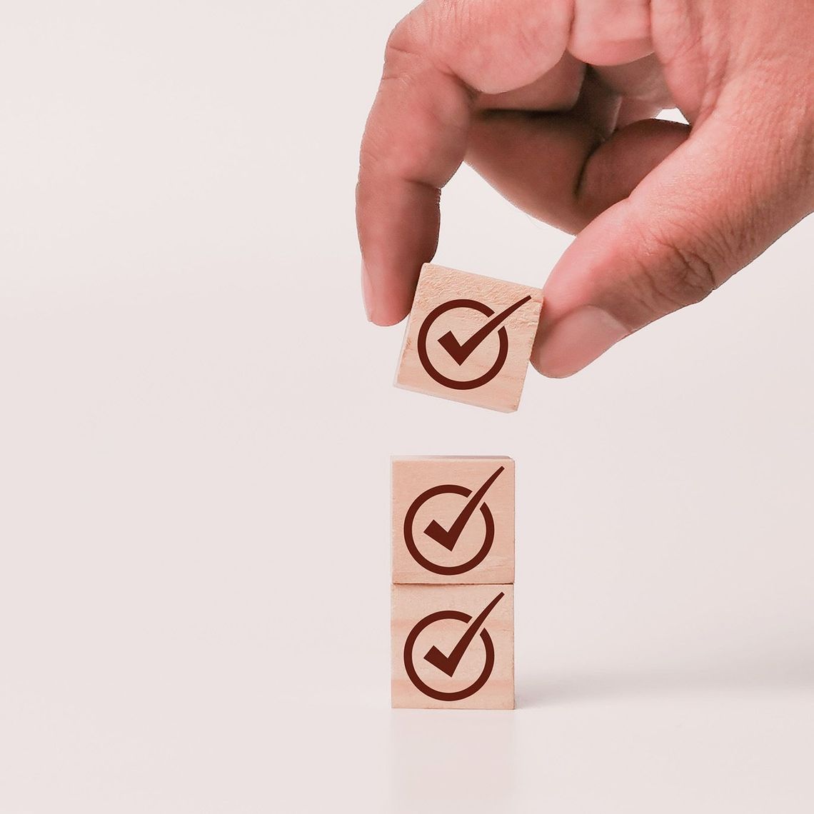 hand stacking check mark blocks